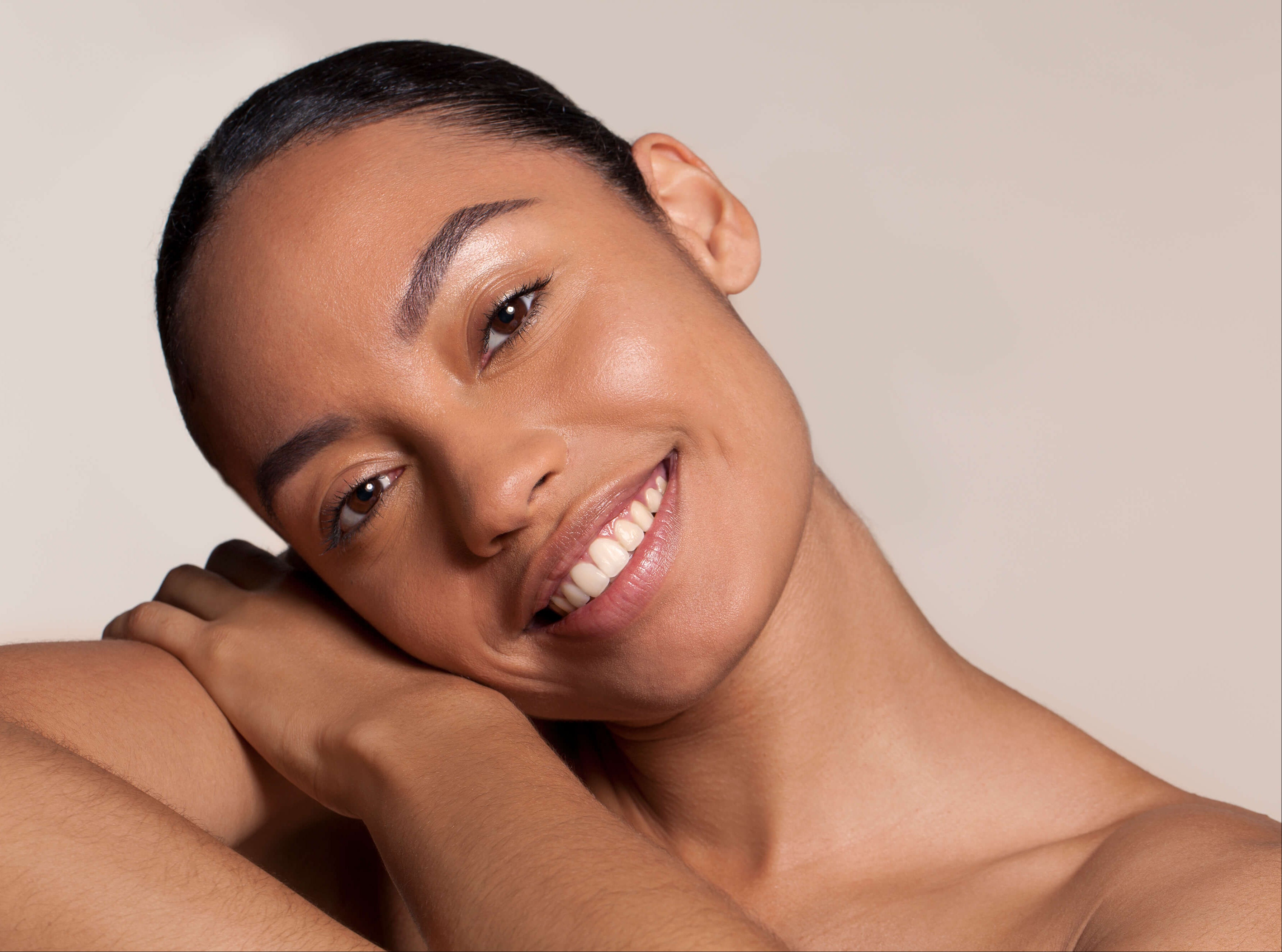 Woman with a radiant smile against a neutral background